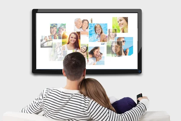 Paar schaut Fotos im großen Fernseher. — Stockfoto