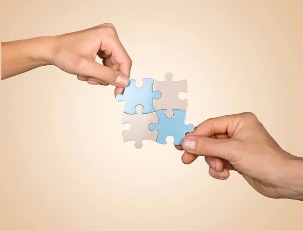 Hands joining puzzle parts — Stock Photo, Image