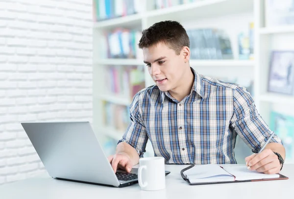 Happy young man works on his laptop — Stock Photo, Image