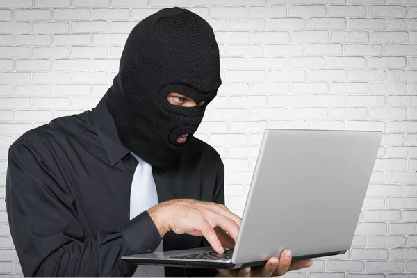 Krimineller Hacker mit Laptop — Stockfoto