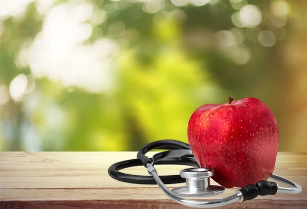 Красное яблоко и стетоскоп — стоковое фото