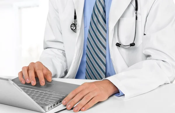 Medico di sesso maschile utilizzando computer portatile — Foto Stock