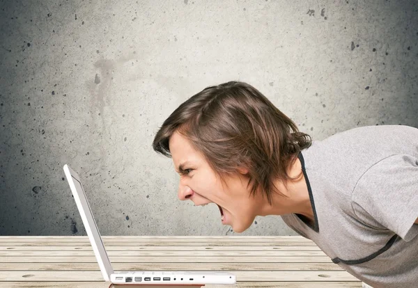 young man screaming on laptop