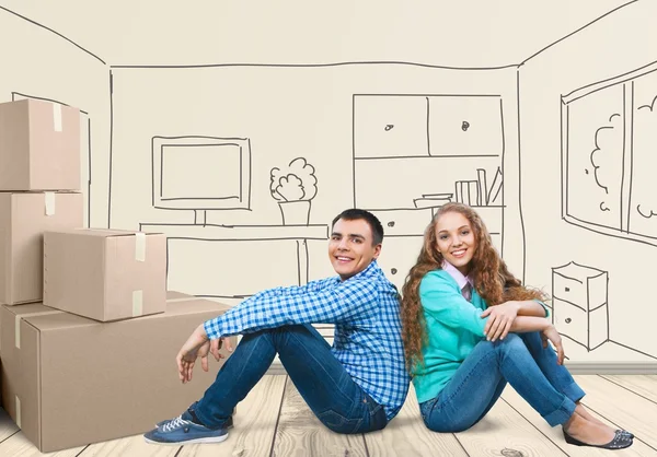 Щаслива молода пара сидить на підлозі — стокове фото