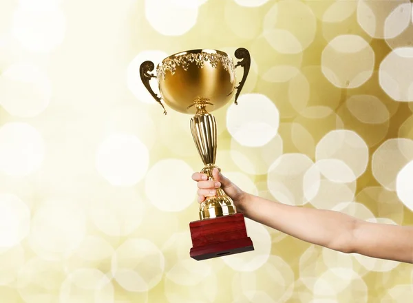 Mão segurando troféu dourado — Fotografia de Stock