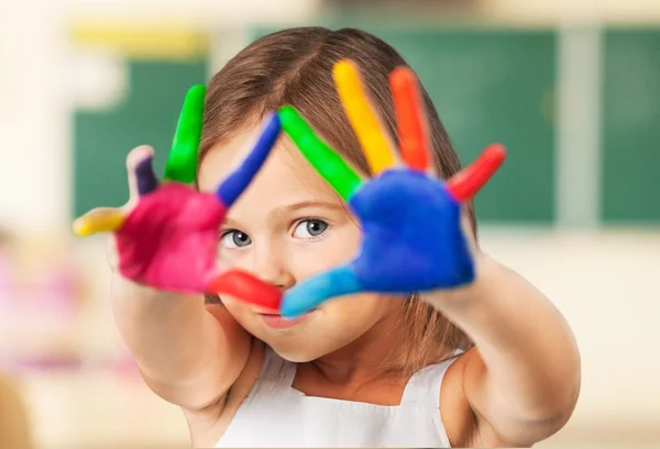 Schattig klein meisje met kleurrijke handen — Stockfoto