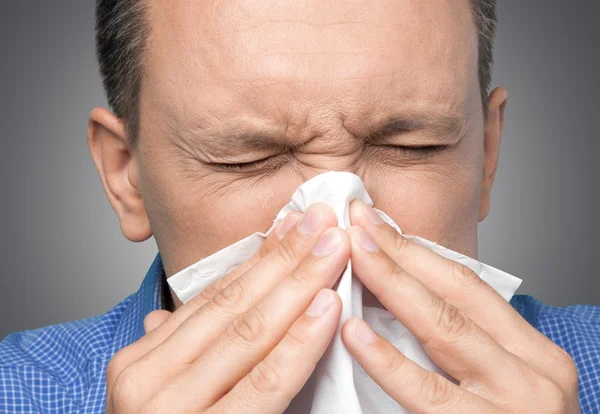 Schöner Mann bläst sich die Nase platt — Stockfoto