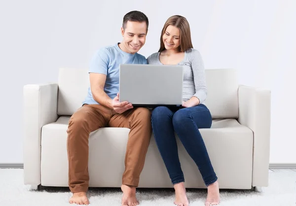 Ler par med laptop på soffa — Stockfoto