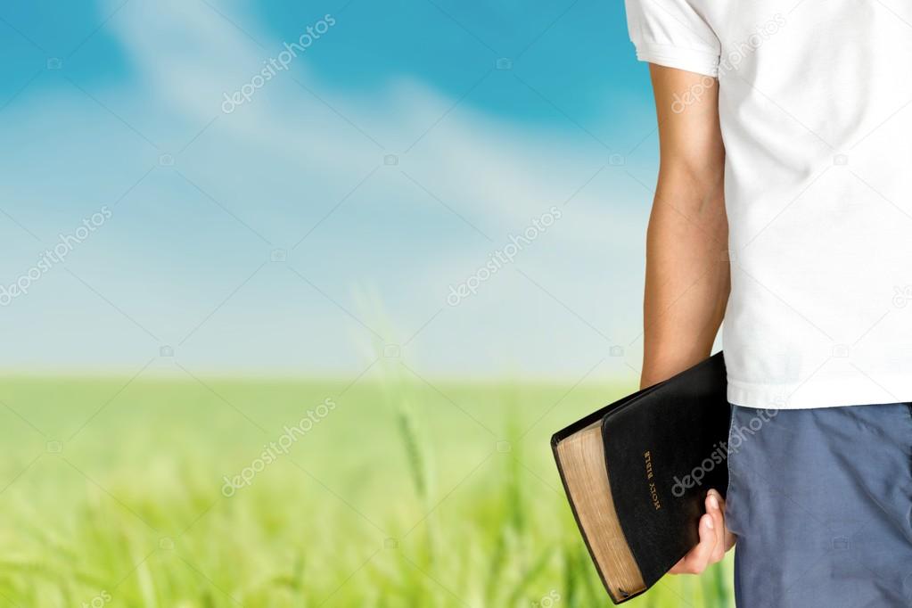 Man holding  bible book 