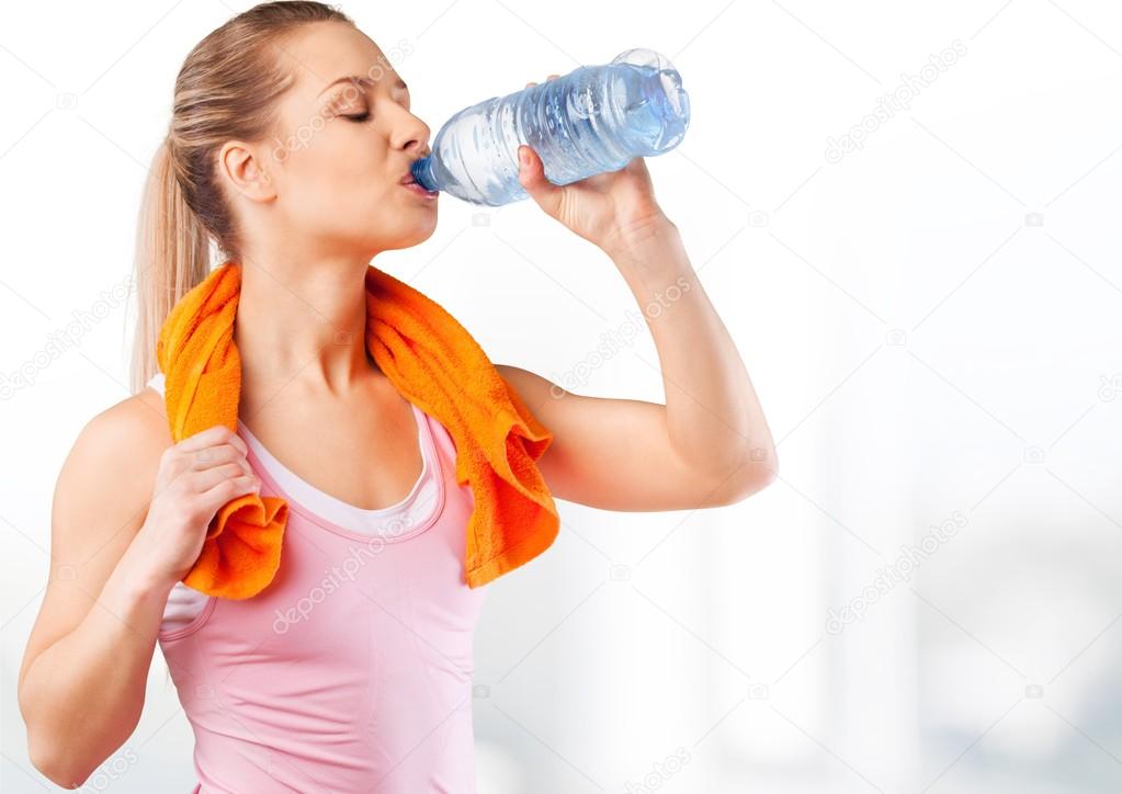  woman drinking water after work out