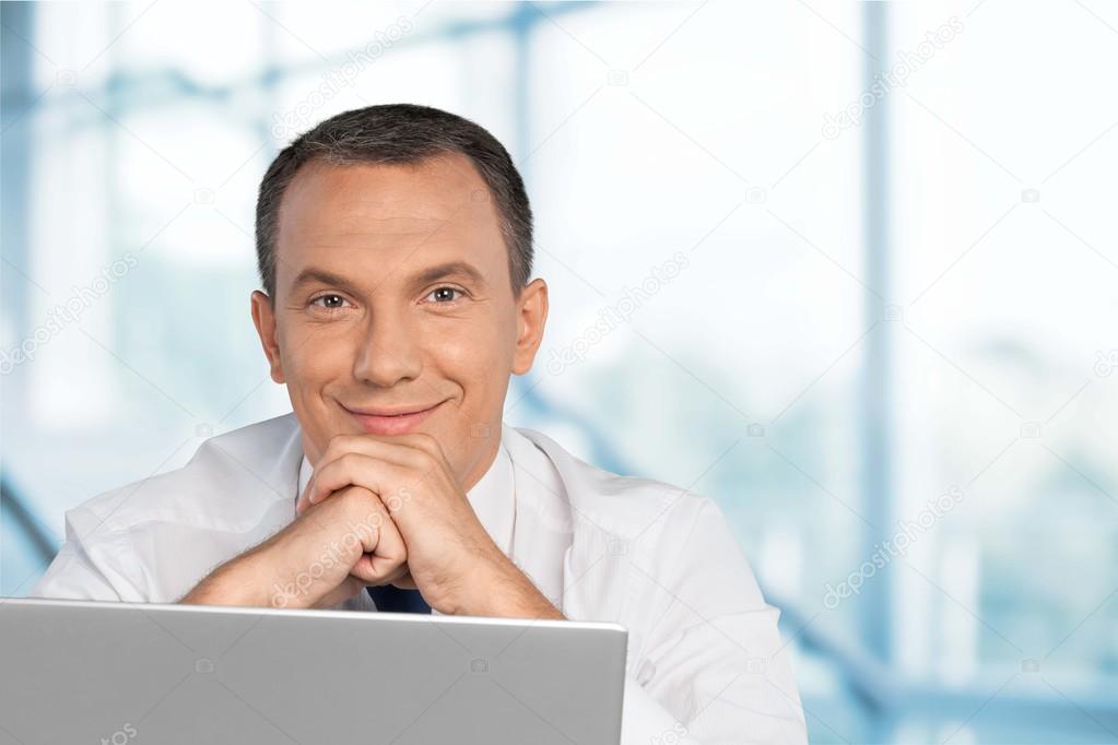 Portrait of happy businessman with laptop