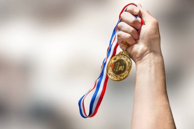 Arka planda altın madalyayı tutan, kazanan ve başarılı konsept.