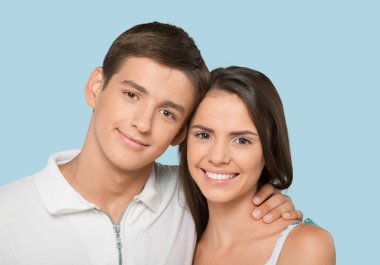 Mavi arka planda mutlu, genç, güzel bir çift