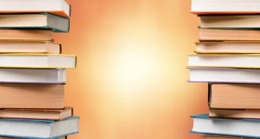 Pastel arkaplan üzerine birçok kitap yığını