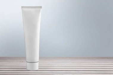 Kozmetik şişe tüpü ambalajı ve beyaz arka plan ahşap tabaktaki uzun gölge güzellik konsepti.