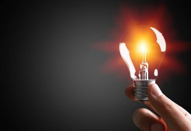 Yaratıcı yeni fikir. Adamın elinde cam bir ampul var..