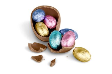 Kırık çikolatalı Paskalya yumurtası ve beyaz arka planda renkli şekerler.