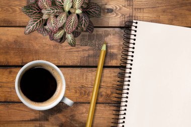Bir defter, bir fincan kahve ve bir kalemle çalışma yeri.