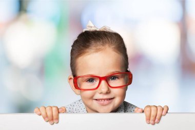 Arka planda beyaz bir boşluk olan gülümseyen küçük kız.