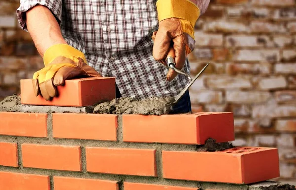 Worker builds a brick wall