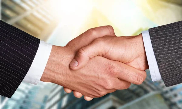 İş tokalaşması ve iş binaları arka planda