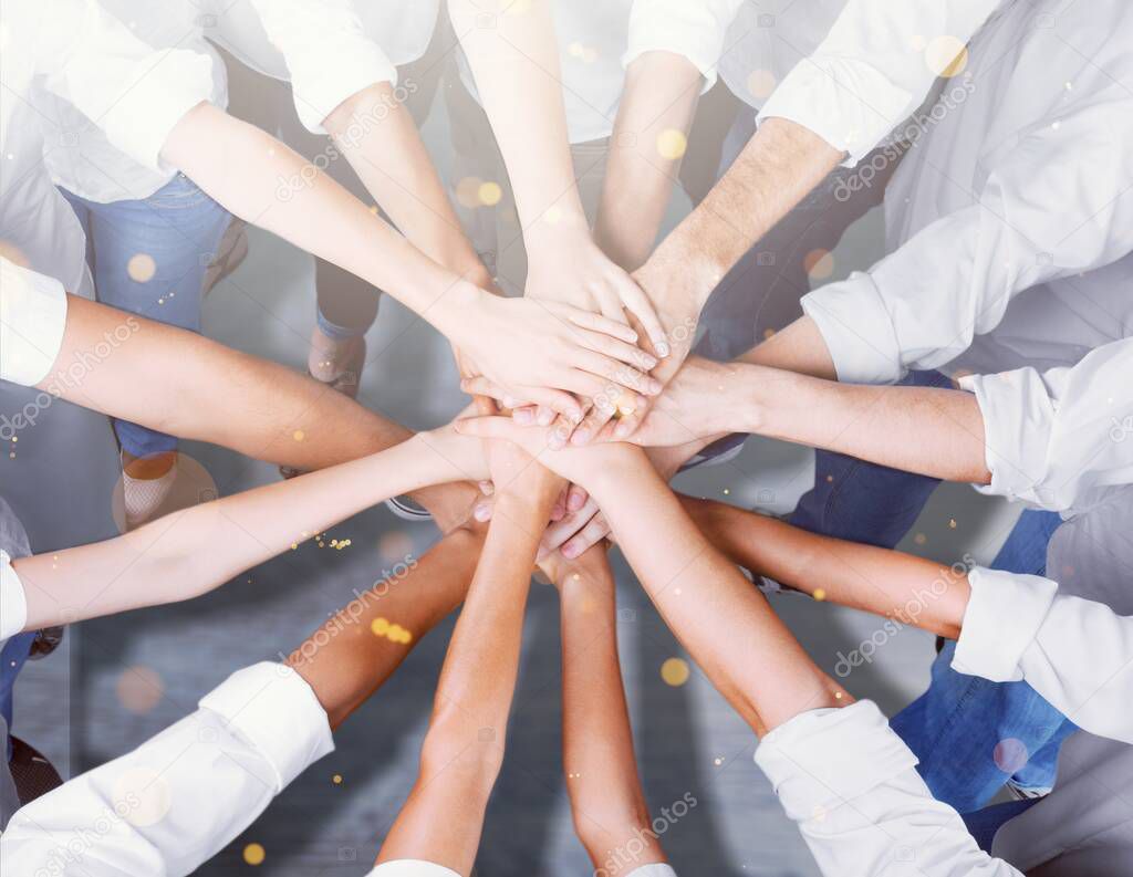 Group of people stacking hands together