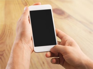 Grafik görüntüleme montajı için boş ekran monitörü olan akıllı telefon kullanan erkek eller.