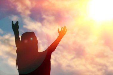 Gökyüzünün arka planında ellerini kaldırmış bir adamın silueti..