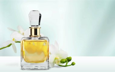 Zarif, şık bir çiçek ve bir şişe kadın parfümü..