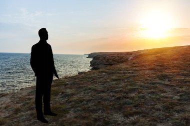 Adam gün batımında güzel sahilde dinleniyor..