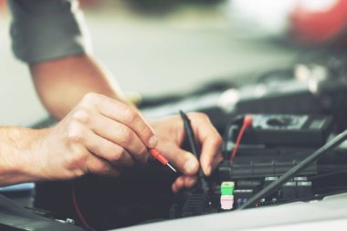 Teknisyenler otomobil elektrik sistemini inceliyor..