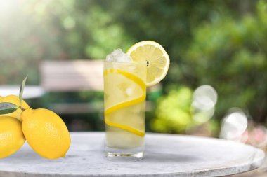 Tahta bir masada taze yapılmış limonata ve narenciye meyveleri..