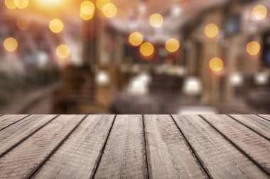 Boş ahşap masa üstü ve bulanık restoran arka planı.