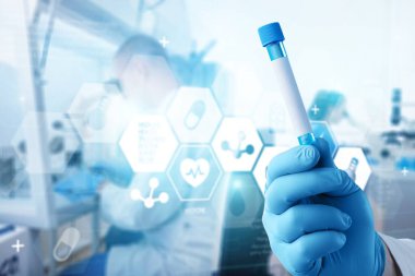 Viorolog araştırmacısı modern bir laboratuarda test tüpünden alınan bir örneği inceliyor..