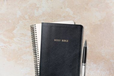 Taş bir masa üzerinde kitap ya da defter yığını