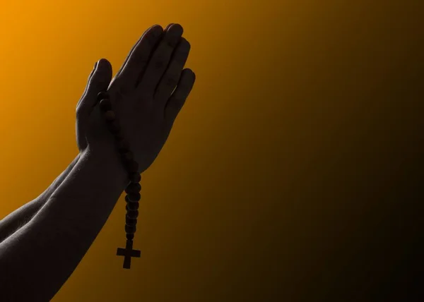 Hands clasped. Man hands in praying position on dark background. Faith in religion