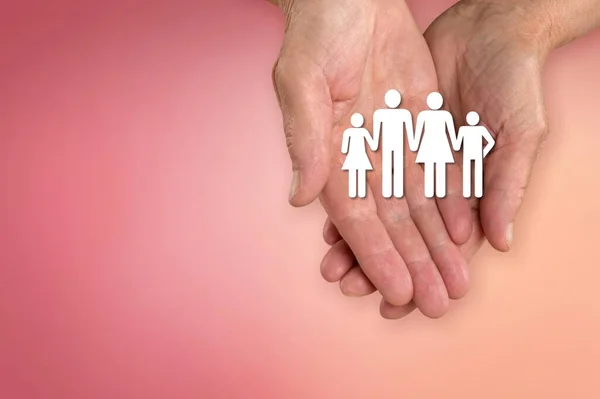 Hand holding family paper cut. Family day concept, foster care, domestic violence concept.