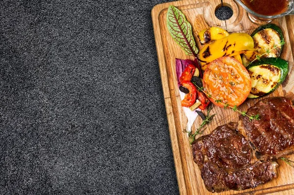 野菜とバターとタイムと木製ボード上のグリルビーフステーキ — ストック写真