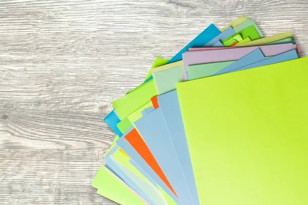 Stack of office or study colored papers on the desk.