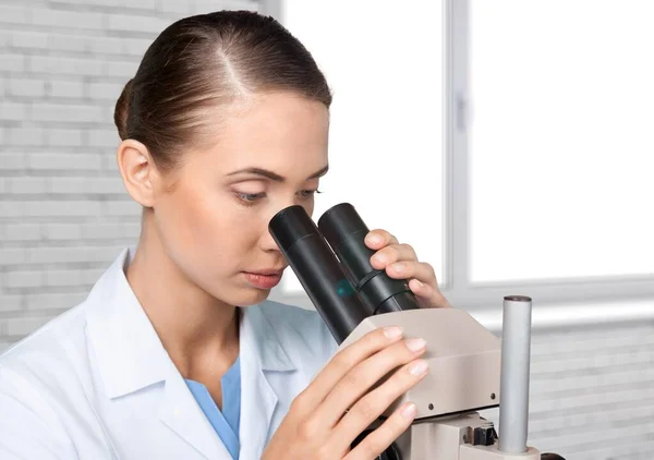医生正在用现代显微镜对生物试管样品进行检测 — 图库照片