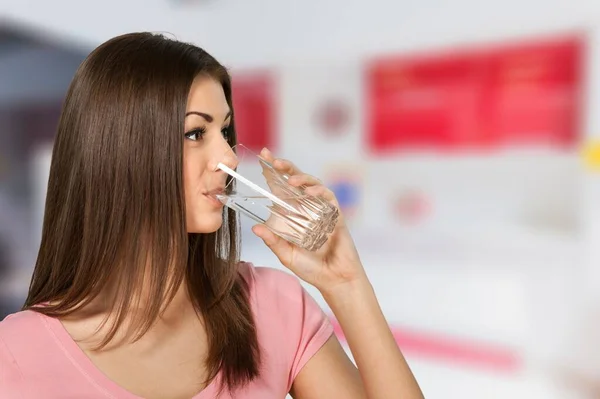 健康的な液体 美しいブルネットの女性は台所のガラスから水を飲む — ストック写真