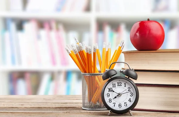 School table with books, stationery in blurred study room