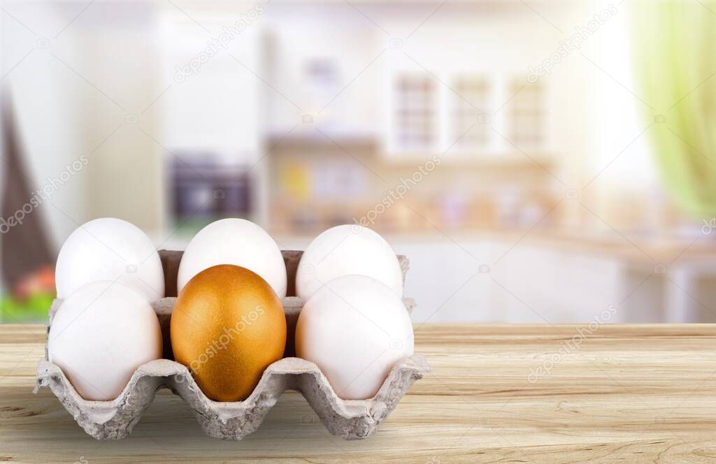 Shiny golden egg among white eggs. The concept of reliability, resistance to adverse conditions.