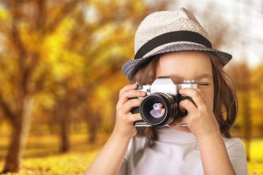 Hippi fotoğrafçı retro kamera kullanıyor. Turist kız anı yakalıyor.