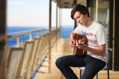 Balkonundan gitar çalan genç bir müzisyen..