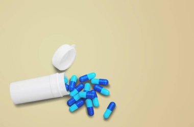 Renk arkaplanındaki metin için şişe, hap ve boşluk içeren düz konum - Görüntü