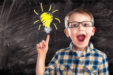 Tahtasında ampul resmi olan erkek ilkokul öğrencisinin portresi.