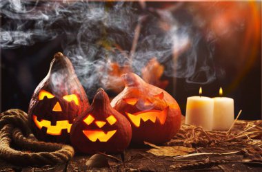 Cadılar Bayramı balkabakları kafa Jack o fener ve ahşap masa üzerinde mumlar