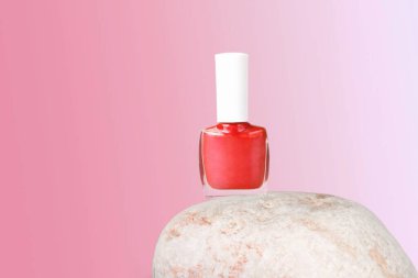 Çivi cilası küçük cam şişeyi doğal taşın üzerine boyuyor. Profesyonel manikür konsepti.