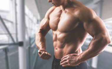 Stüdyoda poz veren fitness mankeni. Güçlü erkek çıplak gövde kasları.